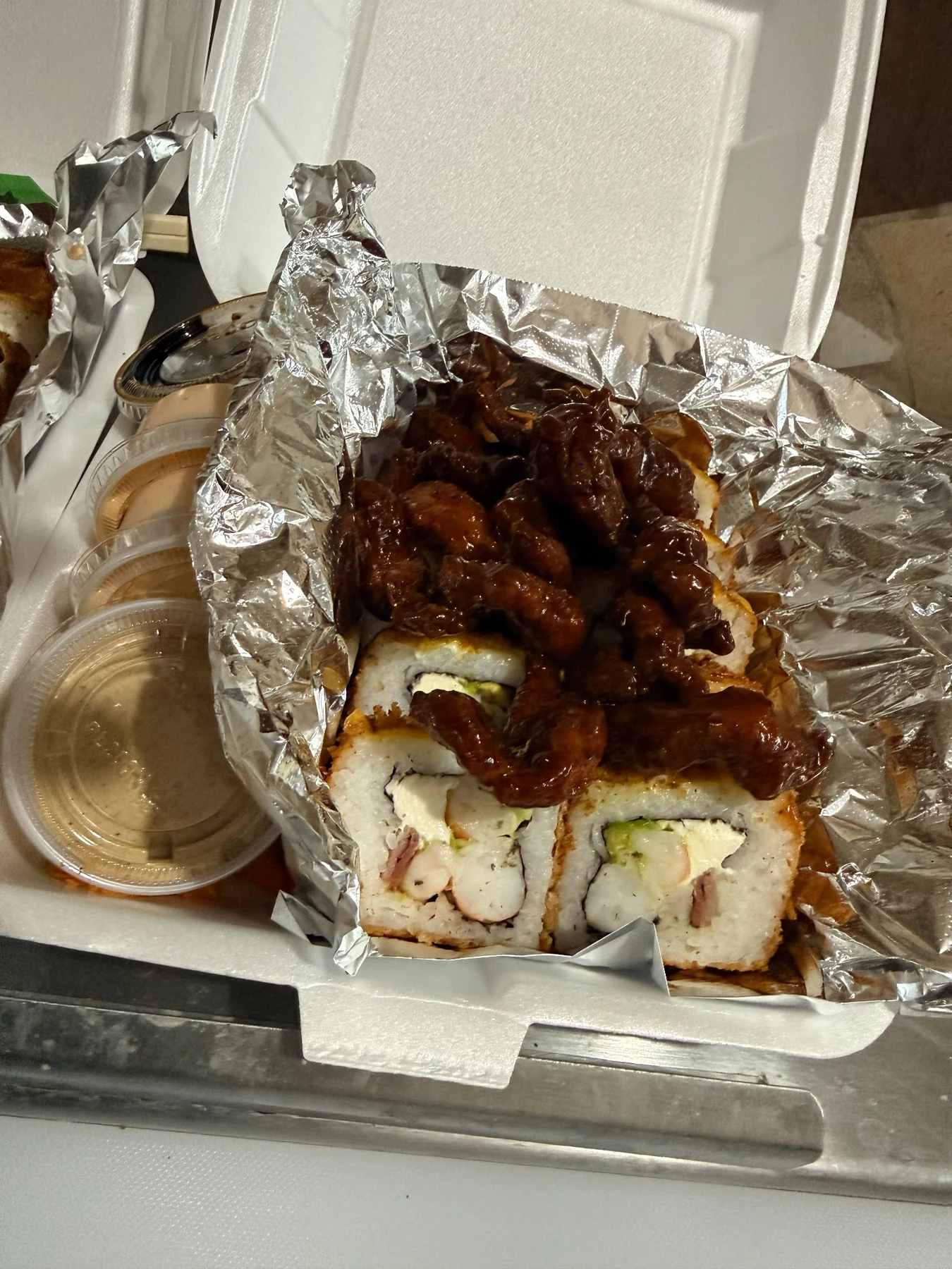 Sushi con boneless y recipientes de salsa